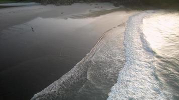 plage paradisiaque avec des vagues de mer se lavant sur le rivage au lever du soleil video