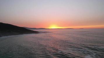 vliegend terug naar de strand met de zonsondergang over- de horizon. hyperlapse video