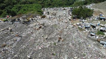 aereo Visualizza di un' città cumulo di rifiuti centro pieno di spazzatura. mandria di mucche mangiare spazzatura nel un' discarica. ecologia e Salute questioni. video