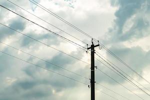 Poste eléctrico de potencia con cable de línea sobre fondo de color cerrar foto