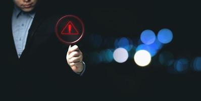 Businessman showing warning triangle warning sign showing system error Concepts of systems, security, anti-virus, and anti-hacking access to critical data. photo