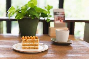 Macadamia caramel cake topping with macadamia nuts with coffee on table. photo