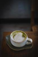 Vertical of fresh matcha green tea late art on wooden background. photo