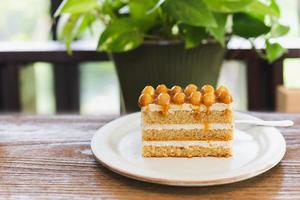 Macadamia caramel cake topping with macadamia nuts with coffee on table. photo