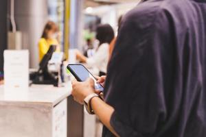 mujeres que usan teléfonos inteligentes mientras esperan la salida en el mostrador del cajero. foto