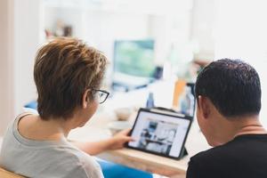 Back view of couple working on laptop at home office. photo