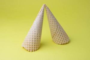 foto creativa de conos de gofres vacíos sobre un fondo amarillo.