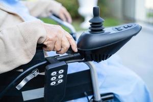 Asian senior or elderly old lady woman patient on electric wheelchair with remote control at nursing hospital ward, healthy strong medical concept photo