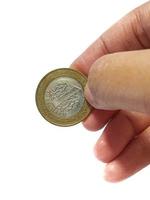 Turkey in June 2022. Isolated white photo of a hand holding a Turkish one lira coin.