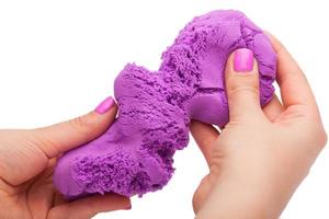 Close-up of a photo in the hands of kinetic sand on a white background