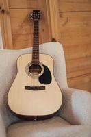 full size classical acoustic guitar on chair in interior. photo