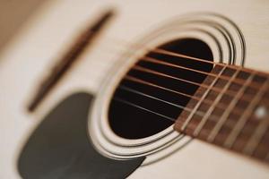 close up of classical acoustic guitar strings and neck with frets. photo