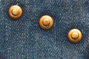 close-up of metal button, rivets on denim texture photo