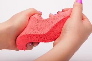 Close-up of a photo in the hands of kinetic sand on a white background