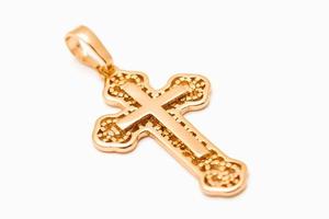 joyería cruz cristiana dorada aislada sobre fondo blanco. foto