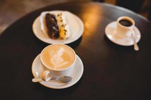 close up a mug of fragrant cappuccino and a sweet dessert on the table photo