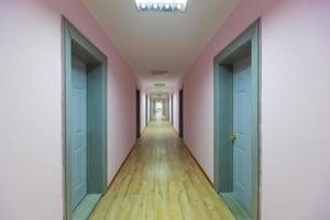 perspective of the empty corridor with many doors photo