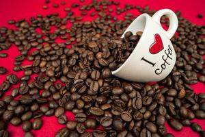 a mug filled with coffee beans on a red background with the inscription i love coffee photo