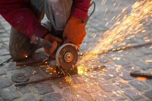 Angular grinding machine cuts metal with sparks photo