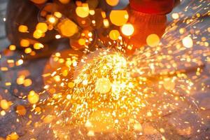 Angular grinding machine cuts metal with sparks photo