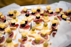 sandwich with sausage cheese and olives on a stick photo