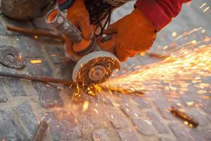 Angular grinding machine cuts metal with sparks photo