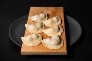 freshly prepared dumplings with kitchen utensils photo