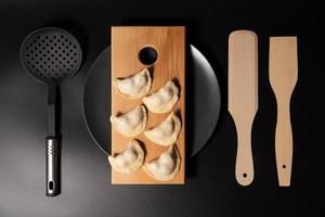 freshly prepared dumplings with kitchen utensils photo