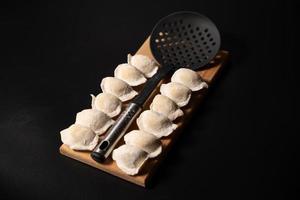 freshly prepared dumplings with kitchen utensils photo