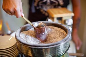 un barista prepara café en una tetera foto