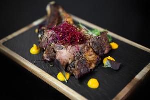 close up of an exquisite serving of a special dish from the chef on a black board photo