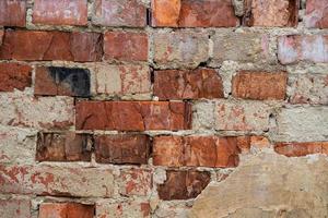 texture of old cracked and destroyed red brick wall photo