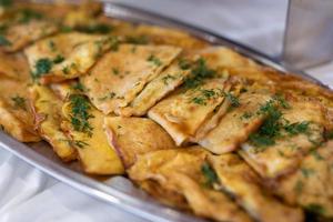 delicious triangular pancakes with greens laid out on a plate. photo