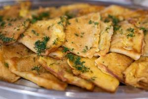 delicious triangular pancakes with greens laid out on a plate. photo