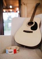 musical instruments, tambourine and acoustic guitar on a chair photo