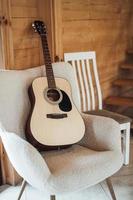 full size classical acoustic guitar on chair in interior. photo