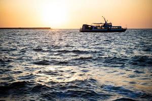 ship at sunset on the sea photo