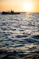 ship at sunset on the sea photo