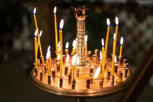 muchas velas encendidas en la iglesia en un stand foto