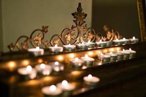 muchas velas encendidas en la iglesia en un stand foto