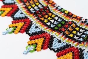 handmade colorful bead necklace close-up isolated on white background. photo