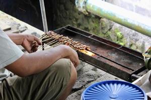 Photo of a pork satay making process in Bali.