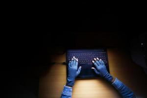 hacker hand stealing data from laptop top down photo