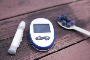 Close up of diabetic measurement tools and blue berry on table photo