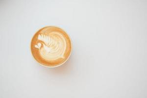 una taza de café tardío con un diseño en forma de flor en la parte superior del café foto