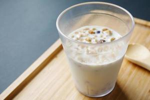 breakfast cereal and mixed with milk in a glass on table photo