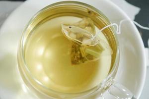 green tea and tea bag on table, close up. photo