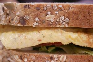 egg sandwich made with brown bread, tomato and lettuce on table photo