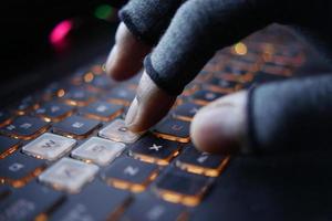 Mano de hacker robando datos de la computadora portátil de arriba hacia abajo foto