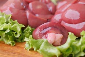 Raw fresh lamb kidneys on a chopping board photo